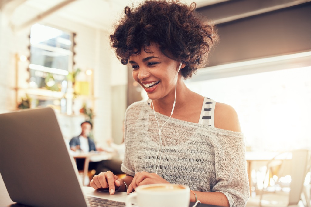 happy-woman-at-cafe-using-laptop